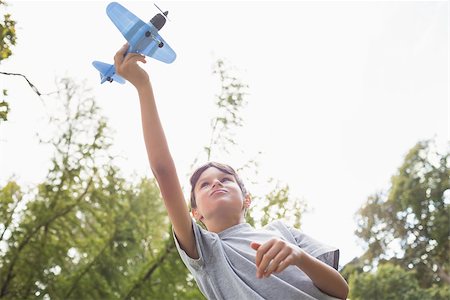 simsearch:400-07474903,k - Boy playing with a toy plane at park on a sunny day Foto de stock - Super Valor sin royalties y Suscripción, Código: 400-08099515