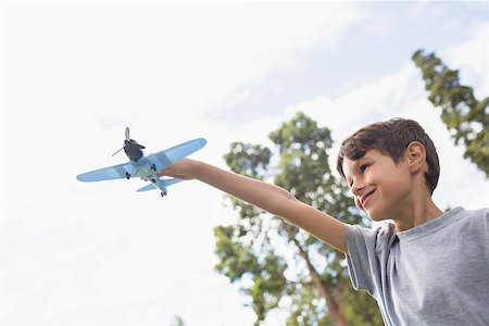 simsearch:400-07474903,k - Boy playing with a toy plane at park on a sunny day Foto de stock - Super Valor sin royalties y Suscripción, Código: 400-08099517