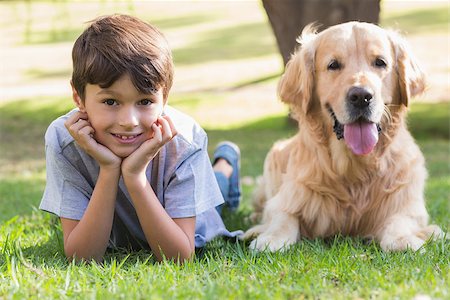 Little boy looking at camera with his dog in the park on a sunny day Stock Photo - Budget Royalty-Free & Subscription, Code: 400-08099528