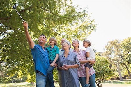 selfie stick - Happy family using a selfie stick in the park on a sunny day Stock Photo - Budget Royalty-Free & Subscription, Code: 400-08099577