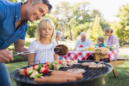 Happy father doing barbecue with her daughter on a sunny day Stock Photo - Budget Royalty-Free & Subscription, Code: 400-08099624