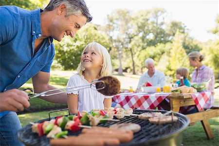 Happy father doing barbecue with her daughter on a sunny day Stock Photo - Budget Royalty-Free & Subscription, Code: 400-08099625