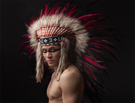 Naked indian strong man with traditional native american make up and headdress looking at the camera. Studio shot Stock Photo - Budget Royalty-Free & Subscription, Code: 400-08093437