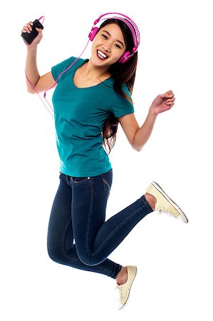 simsearch:400-06690896,k - Pretty girl enjoying music and jumping high in air Stock Photo - Budget Royalty-Free & Subscription, Code: 400-08107216