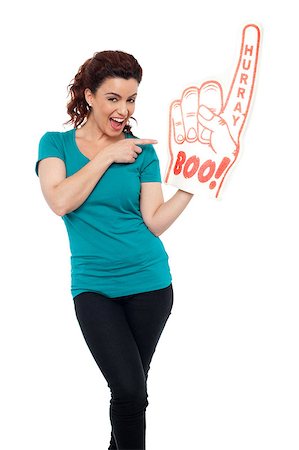 fan and foam finger - Smiling young woman pointing at large foam hand isolated against white background Stock Photo - Budget Royalty-Free & Subscription, Code: 400-08107276