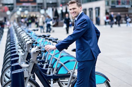 e-bike - Smiling businessman take his bicycle from parking Fotografie stock - Microstock e Abbonamento, Codice: 400-08108435