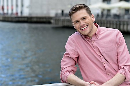 simsearch:400-08110461,k - Young smiling man stands near railings Foto de stock - Super Valor sin royalties y Suscripción, Código: 400-08108456