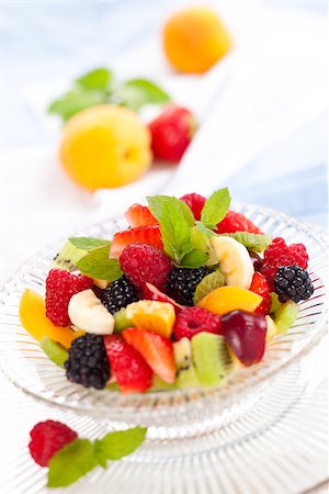 simsearch:400-08110674,k - Fruit salad with mint in a bowl. Focus on raspberry and parts of mint leaves in the center of the bowl. Stockbilder - Microstock & Abonnement, Bildnummer: 400-08108740