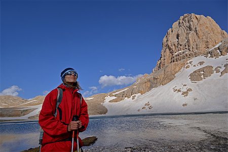 simsearch:400-07176526,k - Woman is pleased with mountain travel. Rocks with snow and blue sky are in the background. Stock Photo - Budget Royalty-Free & Subscription, Code: 400-08108850