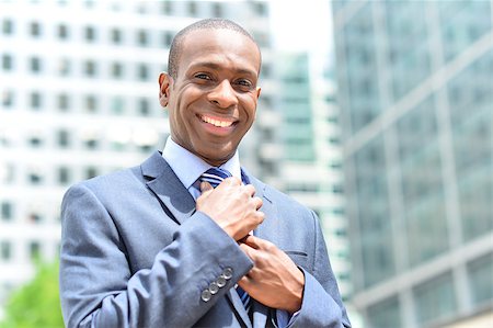 simsearch:400-04674632,k - Handsome african businessman adjusting his tie and smiling Foto de stock - Super Valor sin royalties y Suscripción, Código: 400-08108939