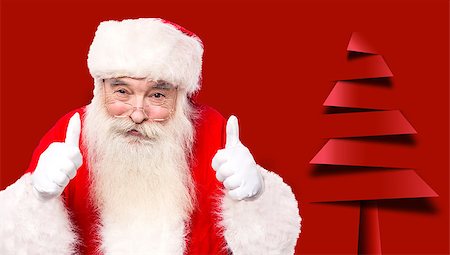 simsearch:640-02953152,k - Santa claus gesturing thumbsup against christmas tree Photographie de stock - Aubaine LD & Abonnement, Code: 400-08109245