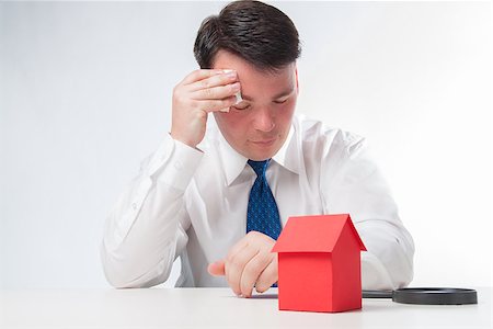 simsearch:400-07952800,k - Sad Man with a magnifying glass and paper house. Real estate concept on a white background Fotografie stock - Microstock e Abbonamento, Codice: 400-08109827