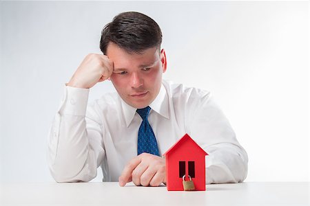 simsearch:400-07952800,k - Sad Man with red paper house. Real estate concept on a white background Fotografie stock - Microstock e Abbonamento, Codice: 400-08109828