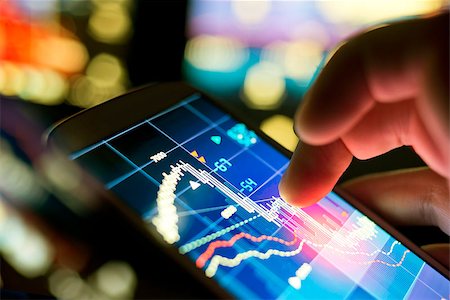 A businessman using a mobile phone to check stock market data. Photographie de stock - Aubaine LD & Abonnement, Code: 400-08114113