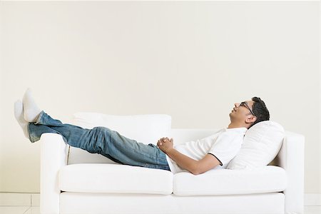 Indian guy daydreaming and rest at home. Asian man relaxed and sleep on sofa indoor. Handsome male model. Stock Photo - Budget Royalty-Free & Subscription, Code: 400-08114439