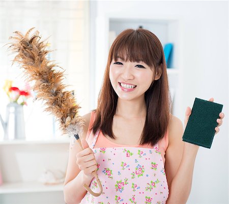 Happy Asian housewife with apron housecleaning, hand holding duster and cleaning sponge. Young woman indoors living lifestyle at home. Stock Photo - Budget Royalty-Free & Subscription, Code: 400-08115338