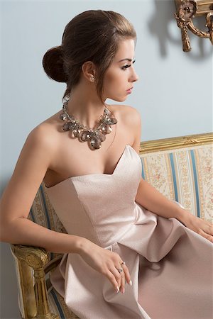 simsearch:400-07981805,k - indoor portrait of aristocratic brunette girl sitting on vintage sofa with elegant pink dress, shiny necklace and classic hair-style. Luxury girl in ancient room Stock Photo - Budget Royalty-Free & Subscription, Code: 400-08116238