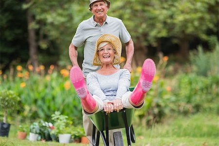 Happy senior couple playing with a wheelbarrow in a sunny day Stock Photo - Budget Royalty-Free & Subscription, Code: 400-08116305