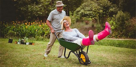 Happy senior couple playing with a wheelbarrow in a sunny day Stock Photo - Budget Royalty-Free & Subscription, Code: 400-08116307