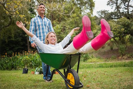 simsearch:400-08116305,k - Happy couple playing with a wheelbarrow on a sunny day Stock Photo - Budget Royalty-Free & Subscription, Code: 400-08116308