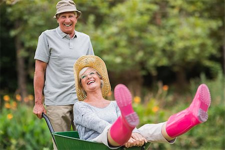 simsearch:400-08116305,k - Happy senior couple playing with a wheelbarrow in a sunny day Stock Photo - Budget Royalty-Free & Subscription, Code: 400-08116302