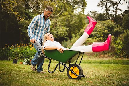 simsearch:400-08116305,k - Happy couple playing with a wheelbarrow on a sunny day Stock Photo - Budget Royalty-Free & Subscription, Code: 400-08116310