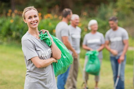 simsearch:400-07336728,k - Happy volunteer collecting rubbish on a sunny day Photographie de stock - Aubaine LD & Abonnement, Code: 400-08116364