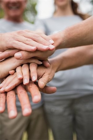 Happy volunteer family putting their hands together on a sunny day Photographie de stock - Aubaine LD & Abonnement, Code: 400-08116368