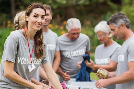 simsearch:400-08116305,k - Happy volunteer looking at donation box on a sunny day Stock Photo - Budget Royalty-Free & Subscription, Code: 400-08116376