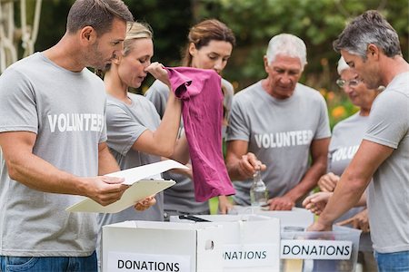 simsearch:400-08116305,k - Happy volunteer looking at donation box on a sunny day Stock Photo - Budget Royalty-Free & Subscription, Code: 400-08116378