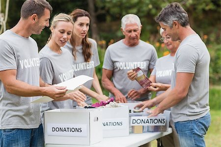 simsearch:400-08116305,k - Happy volunteer looking at donation box on a sunny day Stock Photo - Budget Royalty-Free & Subscription, Code: 400-08116379