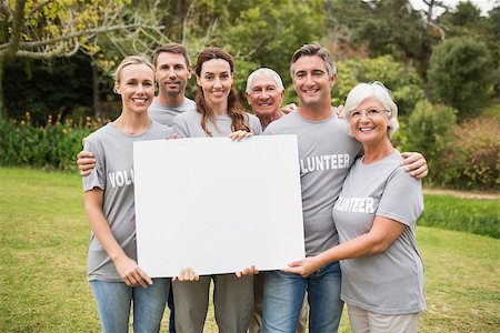 simsearch:400-08116305,k - Happy volunteer family holding a blank on a sunny day Stock Photo - Budget Royalty-Free & Subscription, Code: 400-08116373