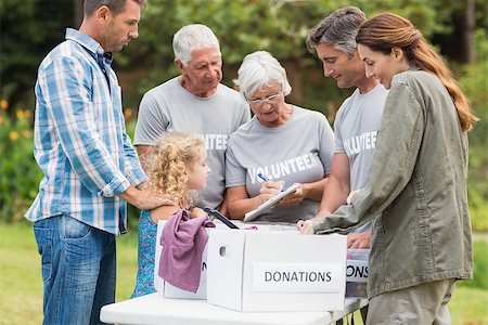 simsearch:400-08116305,k - Happy volunteer family separating donations stuffs on a sunny day Stock Photo - Budget Royalty-Free & Subscription, Code: 400-08116387