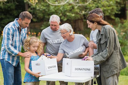 simsearch:400-08116305,k - Happy volunteer family separating donations stuffs on a sunny day Stock Photo - Budget Royalty-Free & Subscription, Code: 400-08116388