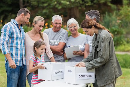 simsearch:400-08116305,k - Happy volunteer family separating donations stuffs on a sunny day Stock Photo - Budget Royalty-Free & Subscription, Code: 400-08116389