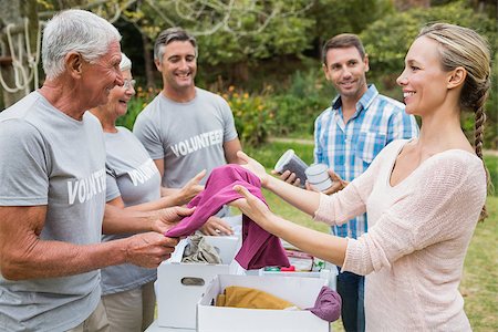 simsearch:400-08116305,k - Happy volunteer family separating donations stuffs on a sunny day Stock Photo - Budget Royalty-Free & Subscription, Code: 400-08116394