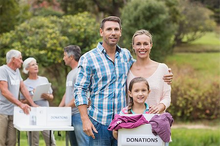 simsearch:400-08116305,k - Happy family holding boxes and smiling at the camera on a sunny day Stock Photo - Budget Royalty-Free & Subscription, Code: 400-08116391