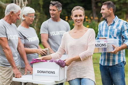 simsearch:400-08116305,k - Happy volunteer family separating donations stuffs on a sunny day Stock Photo - Budget Royalty-Free & Subscription, Code: 400-08116392