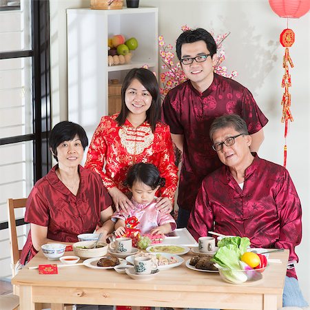 Spring seasons Chinese New Year, reunion dinner. Happy Asian Chinese multi generation family with red cheongsam taking group photo while dining at home. Stock Photo - Budget Royalty-Free & Subscription, Code: 400-08116772