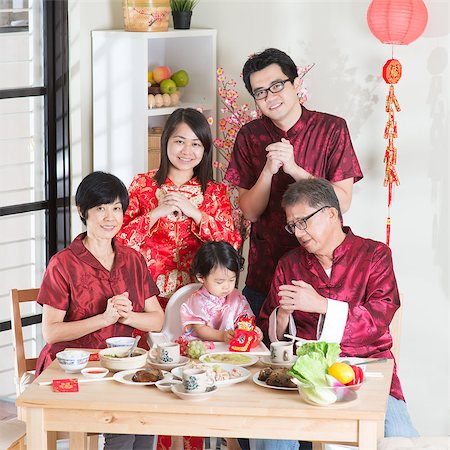 Spring seasons Chinese New Year, reunion dinner. Happy Asian Chinese multi generation family with red cheongsam greeting while dining at home. Stock Photo - Budget Royalty-Free & Subscription, Code: 400-08116773