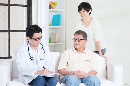 simsearch:400-04080722,k - Doctor and patient. Asian senior couple consult family doctor, sitting on sofa. Senior retiree indoors living lifestyle. Stockbilder - Microstock & Abonnement, Bildnummer: 400-08116792