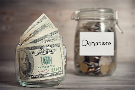 Dollars and coins in glass jar with donations label, financial concept. Vintage tone wooden background with dramatic light. Stock Photo - Budget Royalty-Free & Subscription, Code: 400-08110001