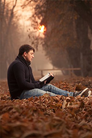 Young man reading a book in the autumn leaves Photographie de stock - Aubaine LD & Abonnement, Code: 400-08110173