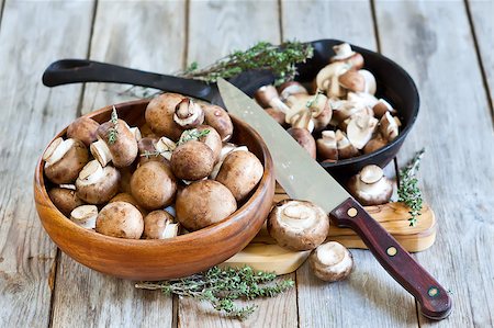 simsearch:400-08011809,k - Fresh raw portabello mushrooms with knife in wooden bowl and small pan on old wood background Photographie de stock - Aubaine LD & Abonnement, Code: 400-08110266