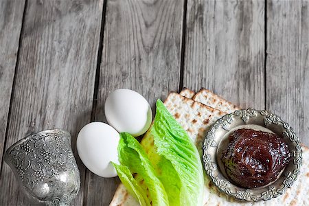 seder table - Wine, egg, bitter salad leaves, matzot and haroset - traditional jewish passover celebration elements. Copy space background. Stock Photo - Budget Royalty-Free & Subscription, Code: 400-08110281