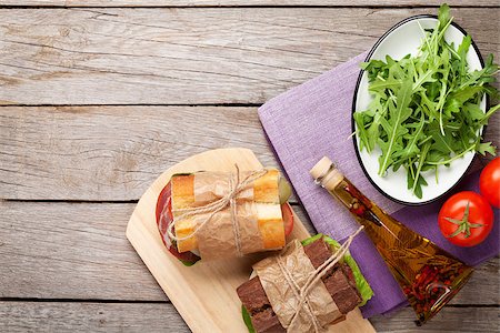 simsearch:400-07099478,k - Two sandwiches with salad, ham, cheese and tomatoes, salad and spices on wooden table. Top view with copy space Stock Photo - Budget Royalty-Free & Subscription, Code: 400-08110609