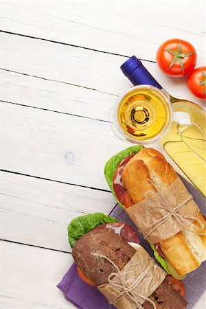 simsearch:400-07099478,k - Two sandwiches with salad, ham, cheese and tomatoes with white wine on wooden table. Top view with copy space Stock Photo - Budget Royalty-Free & Subscription, Code: 400-08110611