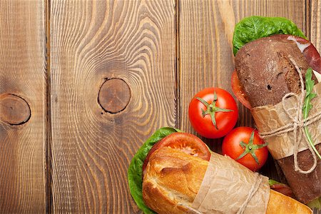 simsearch:400-07099478,k - Two sandwiches with salad, ham, cheese and tomatoes on wooden table. Top view with copy space Stock Photo - Budget Royalty-Free & Subscription, Code: 400-08110613