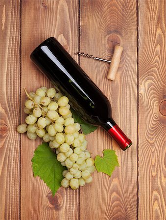 simsearch:400-08110621,k - Red wine bottle and bunch of white grapes on wooden table background Stock Photo - Budget Royalty-Free & Subscription, Code: 400-08110622