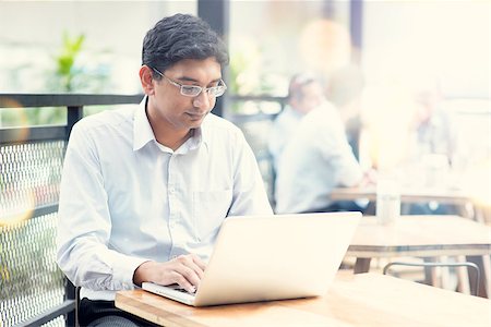 Candid Asian Indian man using laptop computer at outdoor cafe. Stock Photo - Budget Royalty-Free & Subscription, Code: 400-08111376